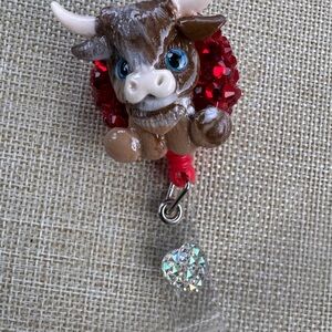 Brown highland cow badge reel with red rinestones